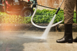 A professional power washing a driveway in El Paso.